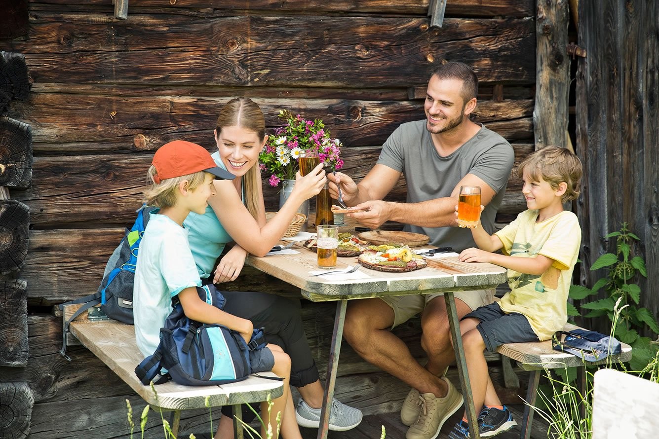 Family hiking tour and rest at an alpine hut